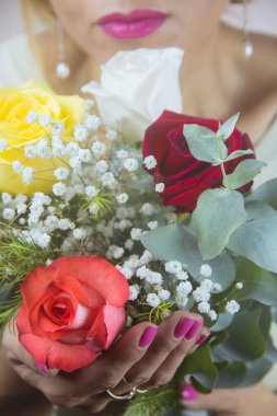 MUJER JUNTO A UN RAMO DE ROSAS COLORIDAS
