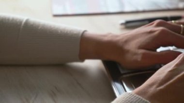 desplazamiento de izquierda a derecha de la camara donde se observa las manos de una mujer tecleando una computadora en plano cerrado