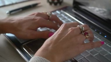   MANOS DE MUJER ESCRIBIENDO EN UN TECLADO DE COMPUTADORA EN UN PLANO  DETALLE FIJO