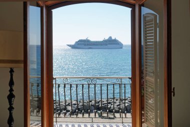 Güneşli bir günde açık mediteranean denizde büyük yolcu gemisi. Balkonun açık kapısından görünüm.