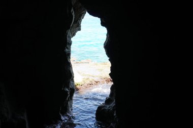 Arkada deniz manzaralı doğal bir deniz mağarasının içine bakan manzara