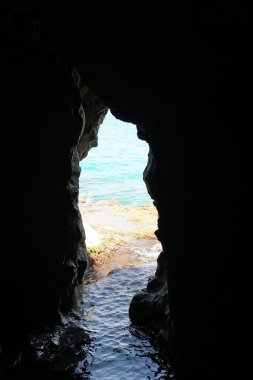Arkada deniz manzaralı doğal bir deniz mağarasının içine bakan manzara