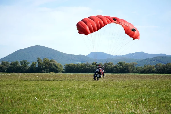 Paracaidista atascado desde un avión utiliza un paracaídas para aterrizar. — Foto de Stock