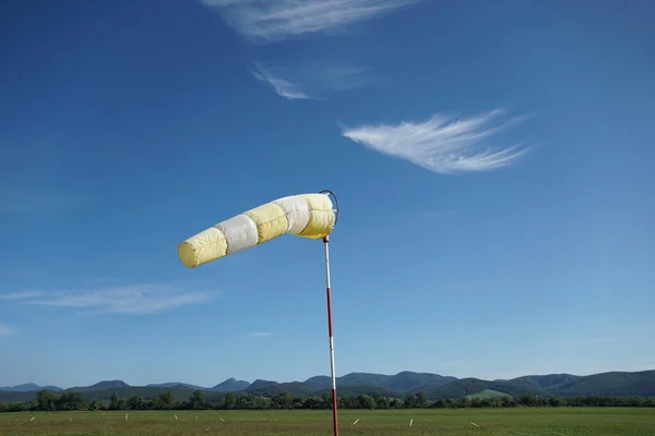 Meia de vento amarelo-branco no fundo do céu azul. — Fotografia de Stock