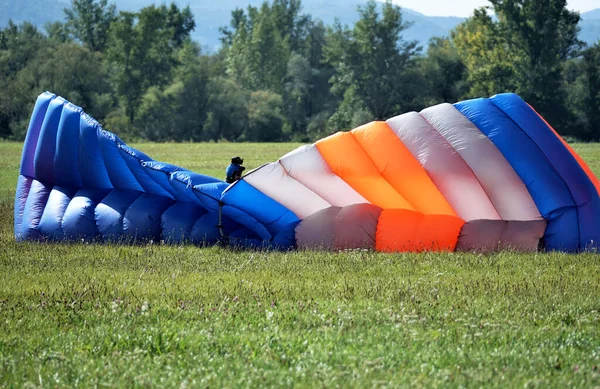 Paraquedistas desembarcados sentados no chão atrás de seu paraquedas. — Fotografia de Stock