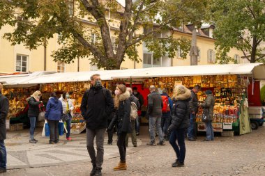 15 Ekim 2020 'de Merano, BZ, İtalya' da sokak satıcıları yüz koruma maskesi takan turistlerin görüntüleriyle tezgah açıyor..