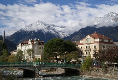 15 Ekim 2020 sonbaharında İtalya 'daki Merano Spa-Town' da. Ön planda Passer Nehri üzerindeki köprü, arka planda karla kaplı Alpler..