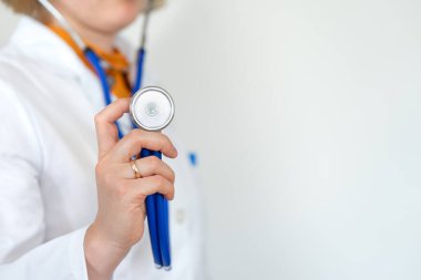 Sağlık ve ilaç, beyaz önlüklü doktor mavi arka planda steteskop tutuyor. kopyalama alanı. Sağlık hizmetleri kavramı.