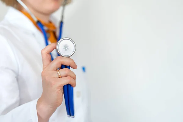 Sağlık ve ilaç, beyaz önlüklü doktor mavi arka planda steteskop tutuyor. kopyalama alanı. Sağlık hizmetleri kavramı.