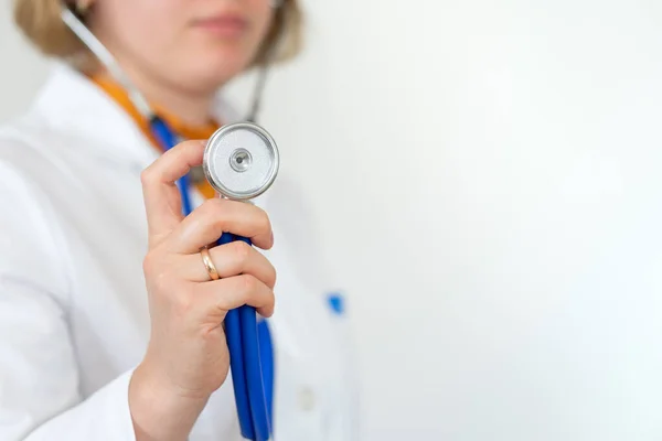 Sağlık ve ilaç, beyaz önlüklü doktor mavi arka planda steteskop tutuyor. kopyalama alanı. Sağlık hizmetleri kavramı
