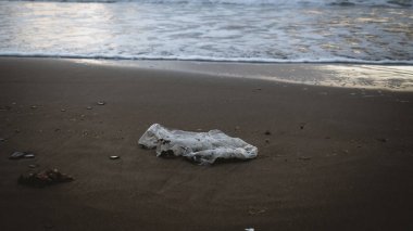 Bir plajın kumsunda çöp ve plastik atık