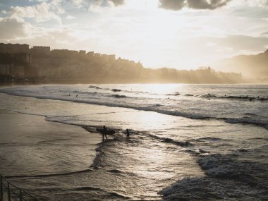 San Sebastian'da sudan çıkan sörfçüler