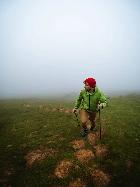 Young man with headlamp hiking through the fog