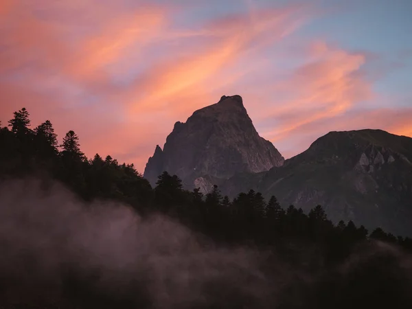 Pico de montaña por encima de la inversión de la nube y el bosque en primer plano y hermoso fondo de la puesta del sol — Foto de Stock