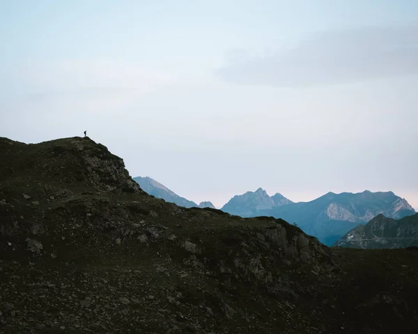 Hombre en la cima de una colina observando el paisaje — Foto de Stock