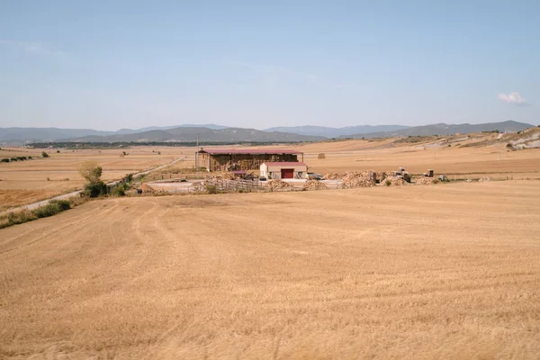 Farm warehouse surrounded by harvested fields