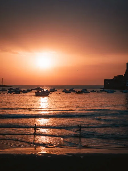 Dos chicas jugando tenis de playa en la costa durante el atardecer — Foto de Stock