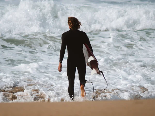 Jeune surfeur entrant dans l'eau — Photo