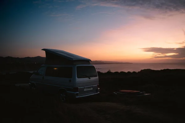 Camper van gün batımı nda dışında sörf masaları ile park