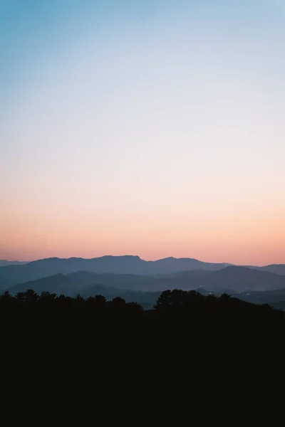 Camadas de cordilheira durante o crepúsculo com um belo céu gradiente — Fotografia de Stock