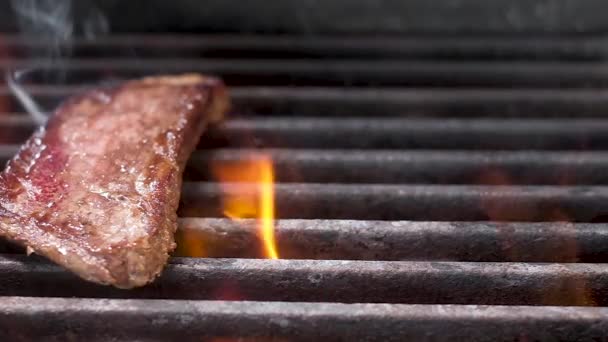 酋长用钳子在热烤架上放了三块嫩的多汁牛排 大量的火和烟 美丽的大理石牛肉在火中煎 周末烧烤 慢动作特写 — 图库视频影像