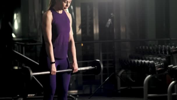 若い女の子はジムでフィットネスに従事しています 運動の解除を行う 夜のトレーニング — ストック動画
