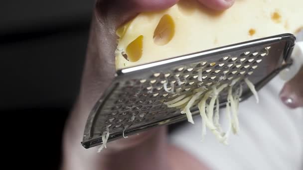 柔らかいチーズは金属おろし器にゆっくりとこすった クローズアップ スローモーション — ストック動画