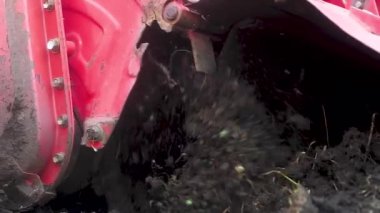 kültivatör yakın çekim, hangi toprak öğütür. Mevsimlik ekimden önce arazinin gevşemesi. Bahar saban. Makine altından uçan toprağın yavaş hareketi.