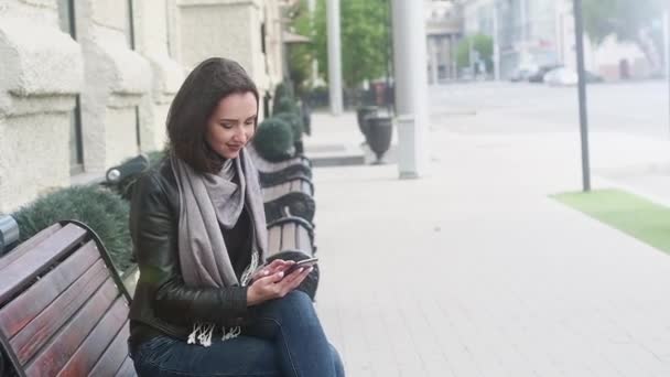 Aantrekkelijk Meisje Een Leren Zwarte Jas Een Grijze Sjaal Zit — Stockvideo