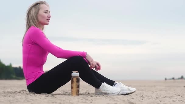 Belle Jeune Femme Sportive Reposant Après Entraînement Sur Plage Boit — Video