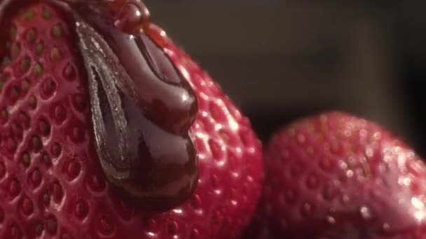 巧克力棕色焦糖大滴倒在红熟多汁的草莓上 缓慢地往 相机在她身后移动 倒在草莓上 宏模式 — 图库视频影像