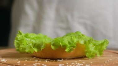 mutfakta beyaz bir önlük şef kabaca hamburger toplar. Agresif bir çörek salatası, kızarmış pirtisu ve soğan atar. Keskin peynir bir dilim terk ediyor ve tüm el aşağı bastırır.