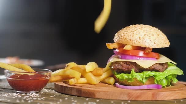 Pommes Frites Faller Ovanpå Kokt Hamburgare Med Sallad Ost Skiva — Stockvideo