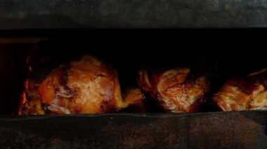 Kapalı siyah ızgara üzerinde gevrek kahverengi kabuk ile kızarmış sulu tavuk bacakları Panoramik çekim. Ateş yanıyor ve barbekü için et hazırlanıyor.