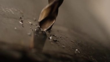 yakın çekim sondaj süreci. Çelik matkap metal keser. Farklı yönlerde uçan küçük keskin Demir Talaşı