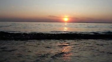 güzel bir gün batımı arka planda yavaş hareket deniz sörfü.