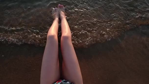 海水の砂の上の指にピンクのペディキュアと美しい細い女性日焼けした脚 上からの眺め 夕方の光のスローモーション — ストック動画