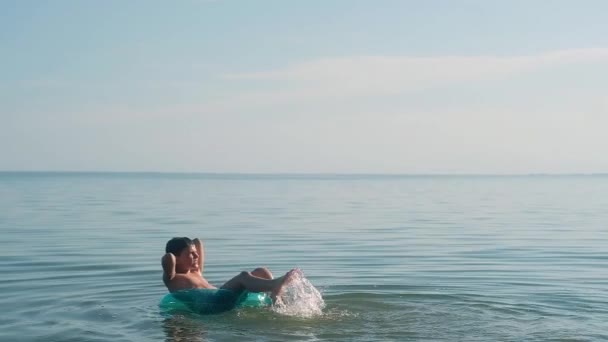 Boy Floating Water Blue Inflatable Circle Dangles His Feet Water — Stock Video