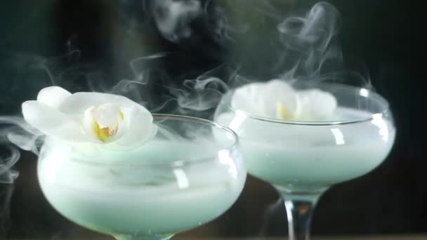 Zblízka Skleněné Skleničky Modrým Koktejlem Bílou Květinou Orchidejí Sprigem Tarragonu — Stock video