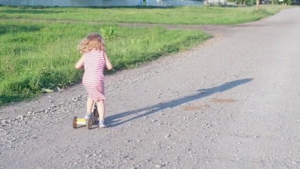 Niña Alegre Con Pelo Rubio Vestido Largo Rayas Monta Triciclo — Vídeos de Stock