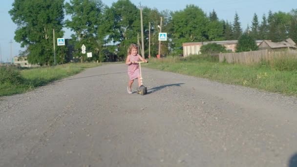 Bambina Con Capelli Biondi Abito Lungo Righe Cavalca Fotocamera Triciclo — Video Stock