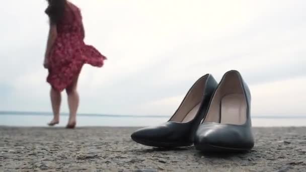 Smukła Dziewczyna Krótkiej Czerwonej Sukience Długimi Włosami Rzuca Ciemnozielone Buty — Wideo stockowe
