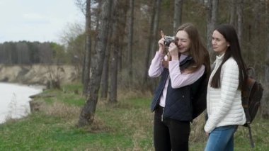 Sırt çantalı iki arkadaş uçurumun tepesinde durur ve klasik kamerayla manzara çekerler. Tatilin veya hafta sonun boyunca Bavul 'la denize güzel bir yolculuk. Kızlar sırtlarında sırt çantasıyla gezerler.