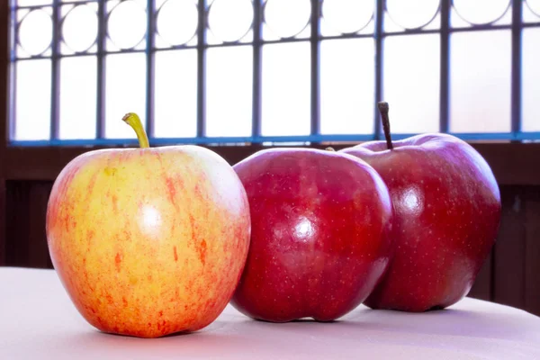 Three red apples in line on the table. Fruit for dieting and important for nutrition.