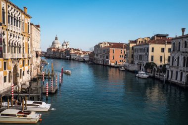 Venedik, gondol botları ve mavi gökyüzü arka planında geleneksel mimari anch kilisesi olan su kanalı manzarası. 