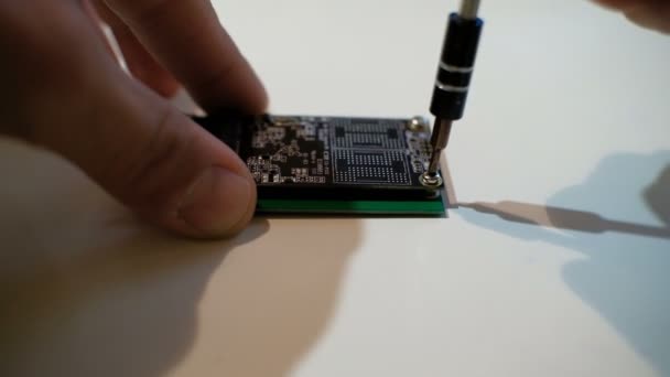 Mani umane che lavorano su componenti di computer chipset ssd con cacciavite, 4k — Video Stock