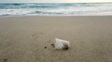 Kumlu deniz kıyısında plastik cam atıkları, kirlenmiş doğa, cilento