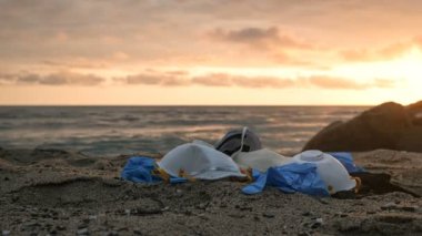 Tıbbi atık, maske ve plastik eldivenler çöp, günbatımı deniz zamanlaması, koronavirüs 