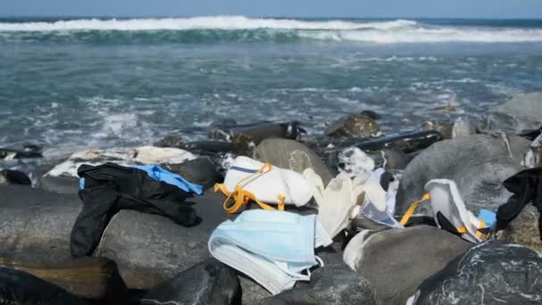 Odpady medyczne, maski i rękawice plastikowe na wybrzeżu morza, koronawirusy skażenia — Wideo stockowe