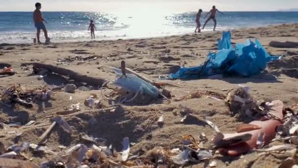 Palinuro, Italien - 15. Juni 2020: Medizinische Abfälle, Maske und Plastikmüll, Kinder spielen am Meeresstrand, Covid19 Umweltverschmutzung — Stockvideo